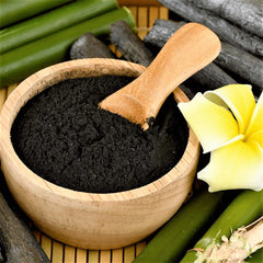 Close-up of activated charcoal black mask in sleek tube with silver cap, showcasing its velvety texture against clean skin