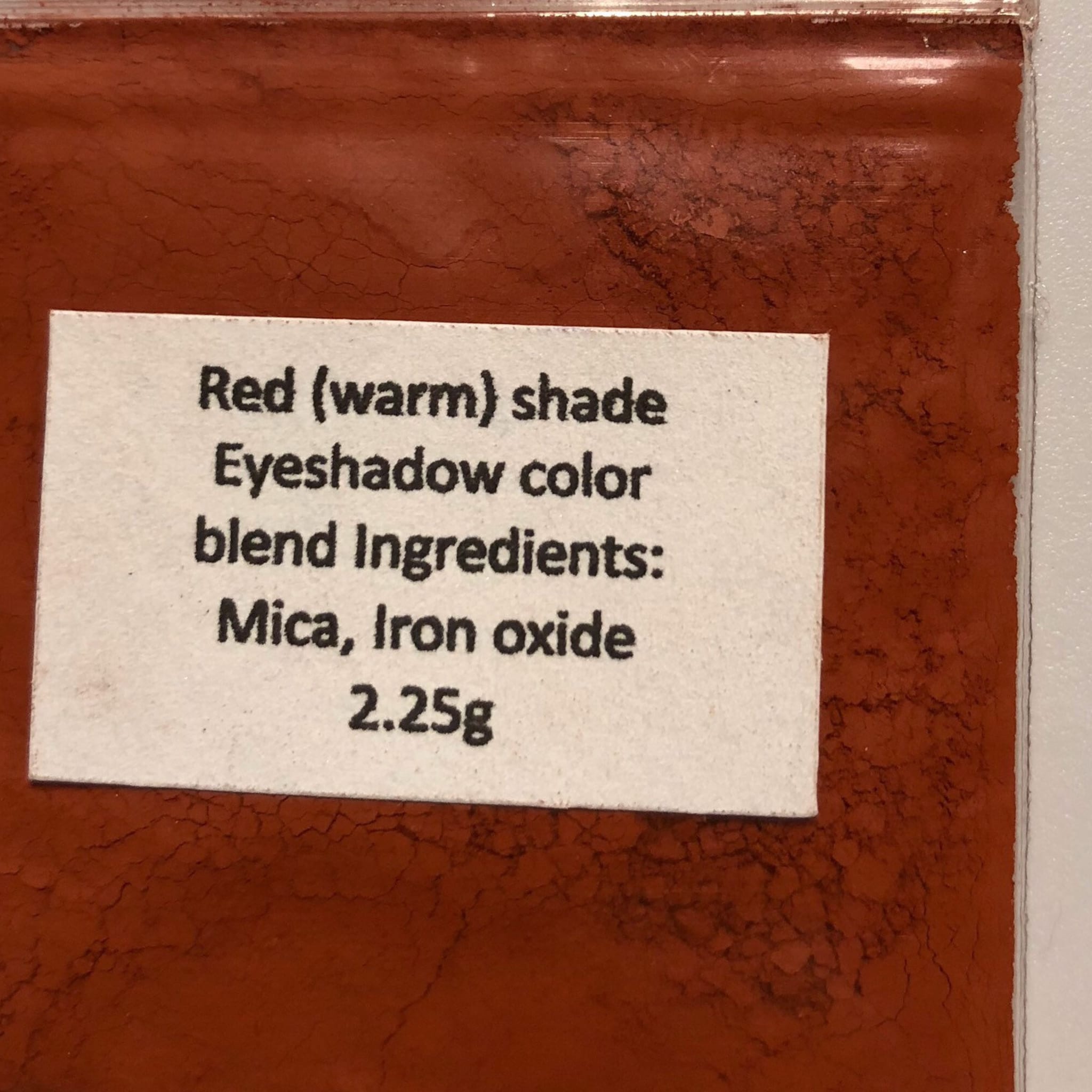 Side view of mineral eyeshadow compact showing soft matte taupe and beige color gradient in square pan