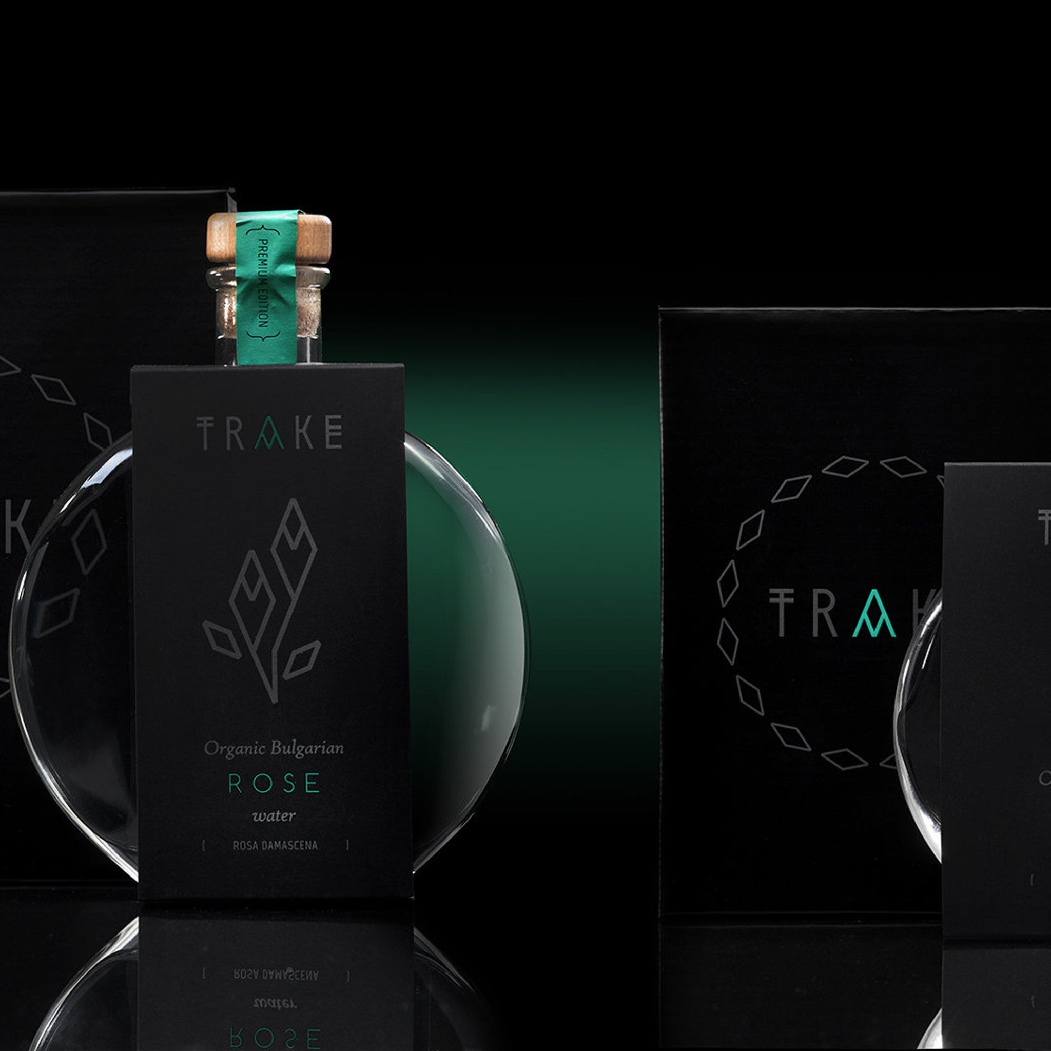 Rose water bottle with black label, glass bottle, and TRAKE brand text