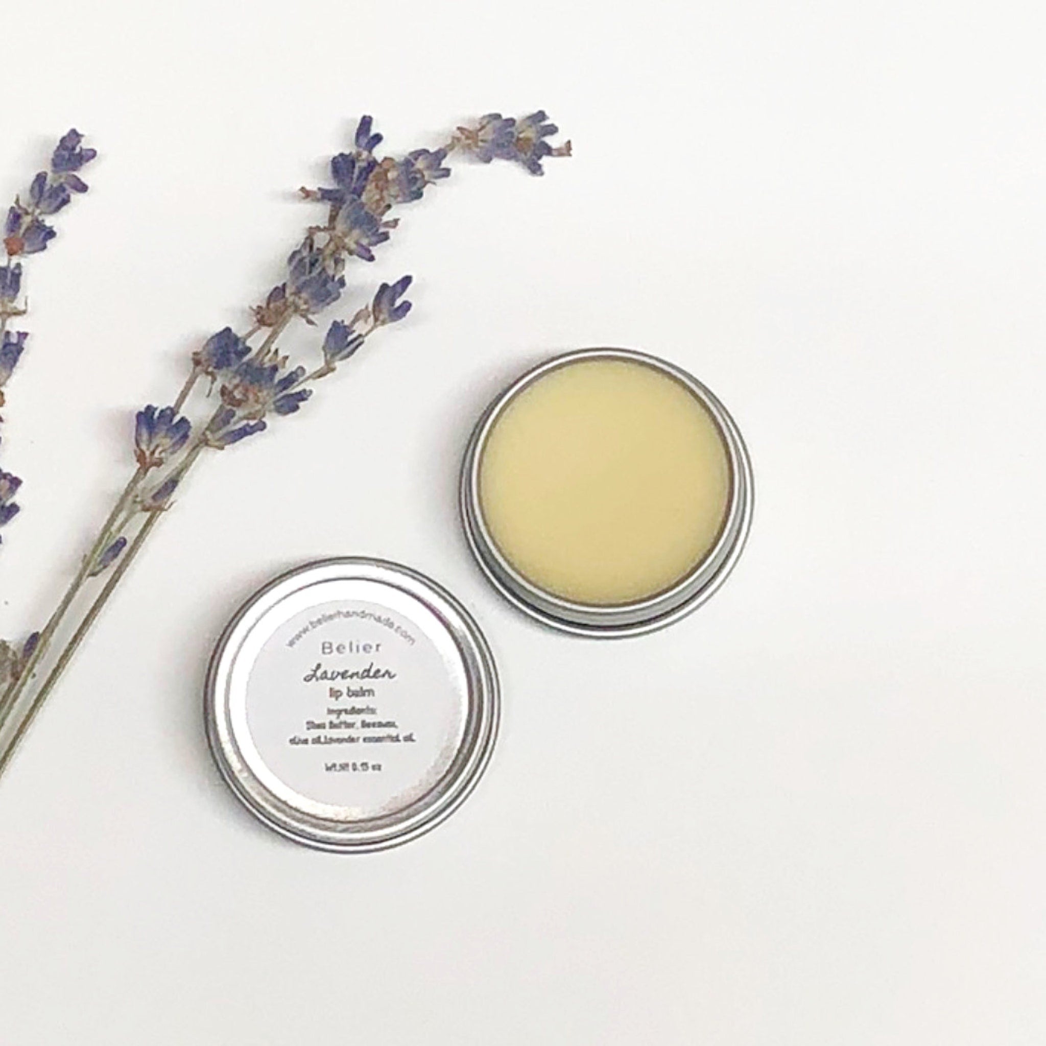 Lip balm in metal tin with lavender sprigs, Belier Lavender text visible, on white background