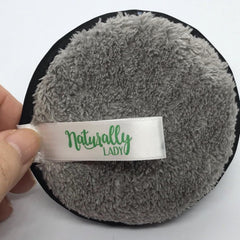 Reusable makeup remover pad with gray microfiber, black trim, and Naturally Lady ribbon