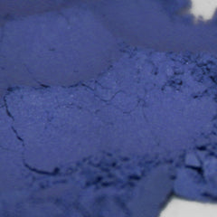 Side view of vegan matte loose powder eyeshadow in blue violet shade, showcasing fine pigment texture