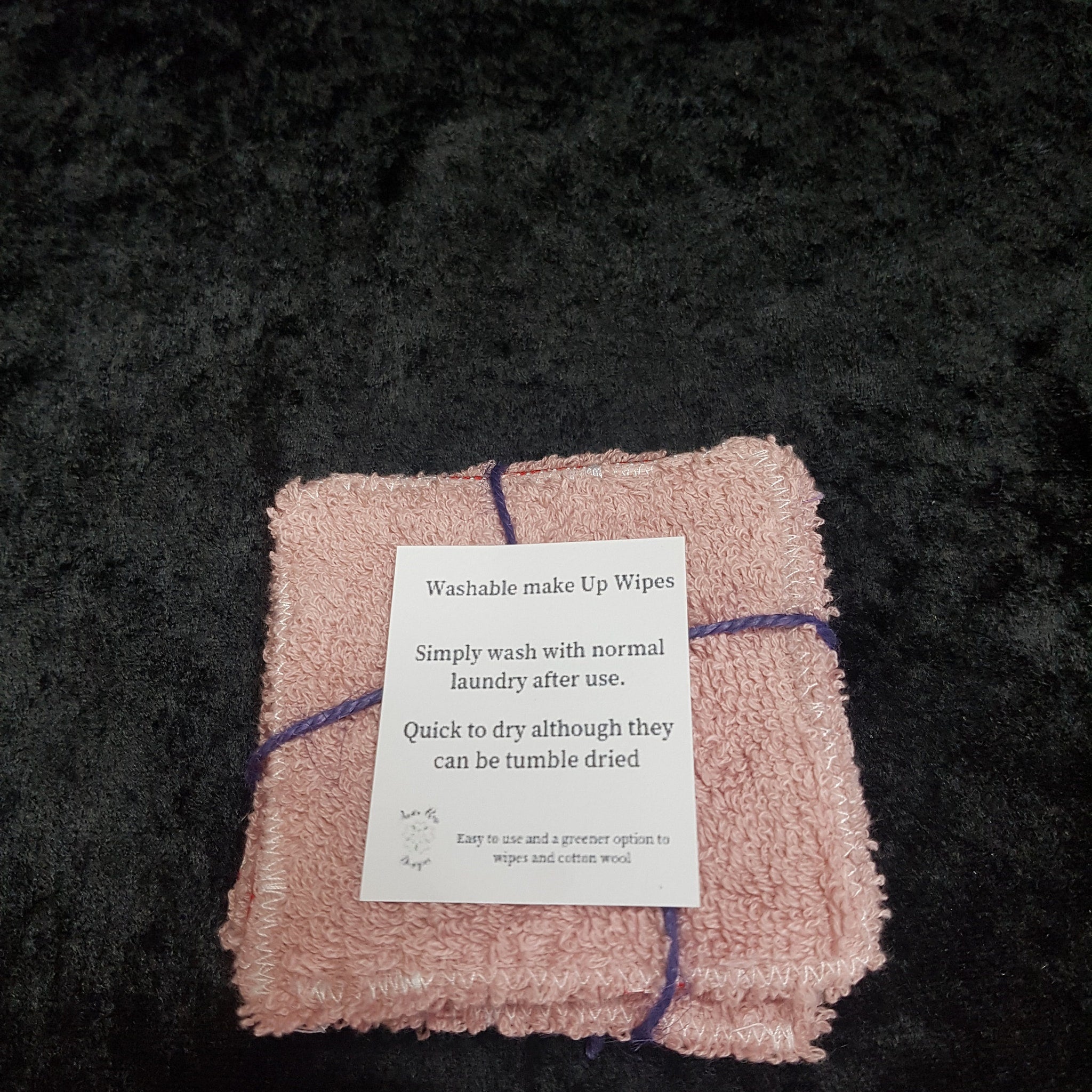 Washable make up wipes in pink, terrycloth material, tied with purple string, with a paper tag