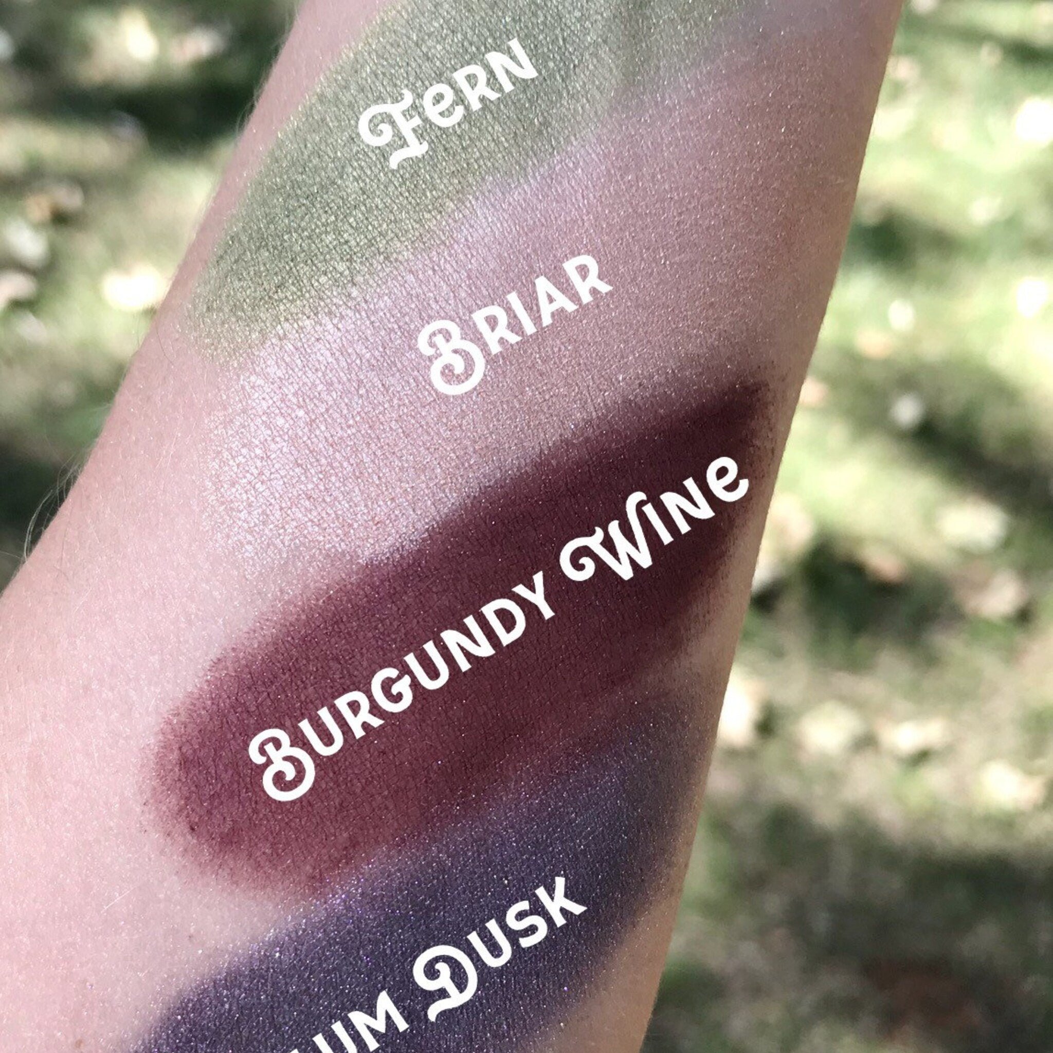 Hand applying loose mineral eyeshadow with brush, showcasing powder texture and natural pigment blend on eyelid