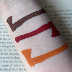 Close-up of matte dark red-brown eyeshadow pan with rich pigmentation for gothic horror makeup looks