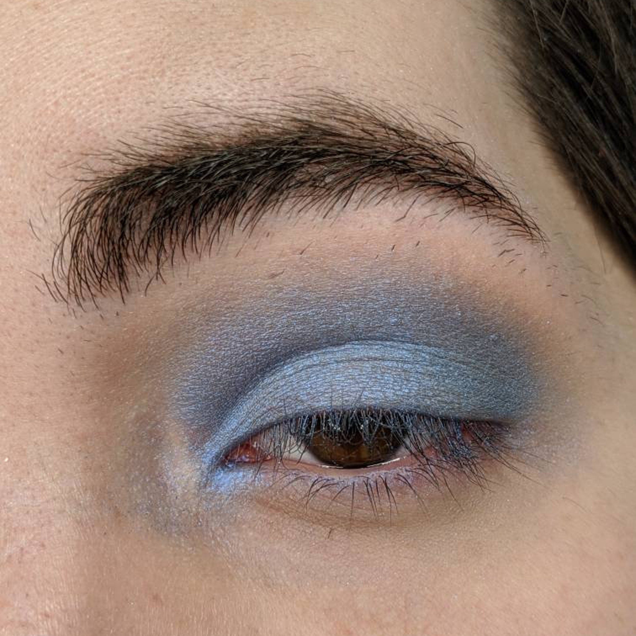 Close-up of pressed sapphire blue eyeshadow pan showing rich pigmentation and smooth matte finish