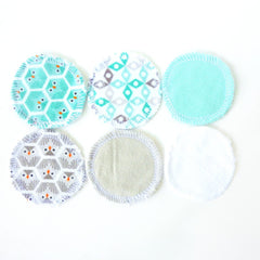 Reusable cotton pads with various patterns and colors, including teal, gray, and white with stitched edges