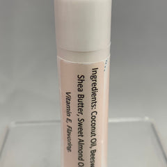 Lip balm tube with white and peach colors, ingredients list visible on label