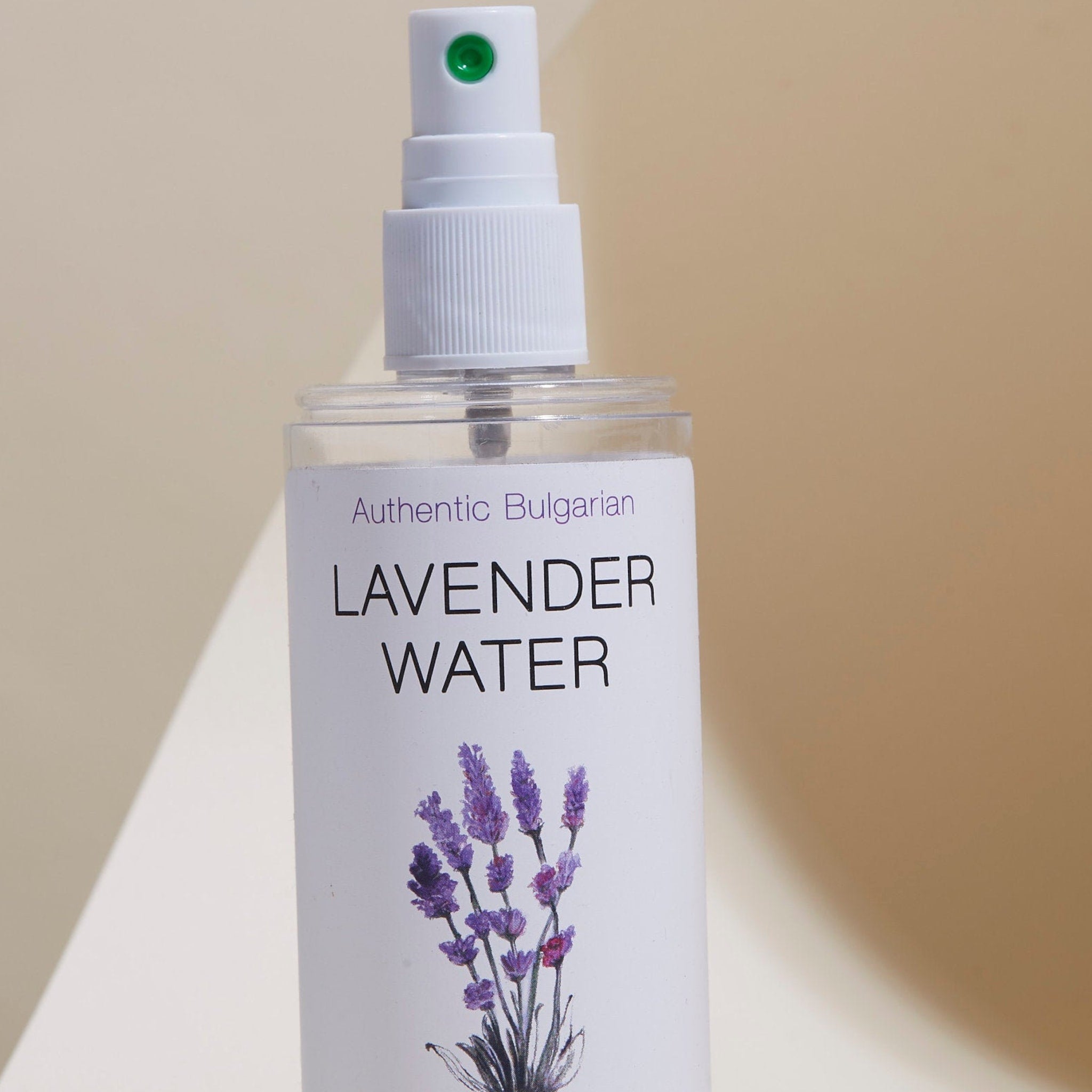 Lavender water spray bottle, white and clear, with purple flower illustration and text label