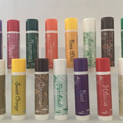 Lip balm tubes with various colored caps and labels, white base, floral pattern
