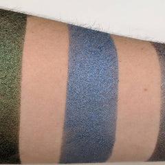 Side angle view of vegan sapphire blue pressed eyeshadow in compact palette showing rich pigment texture