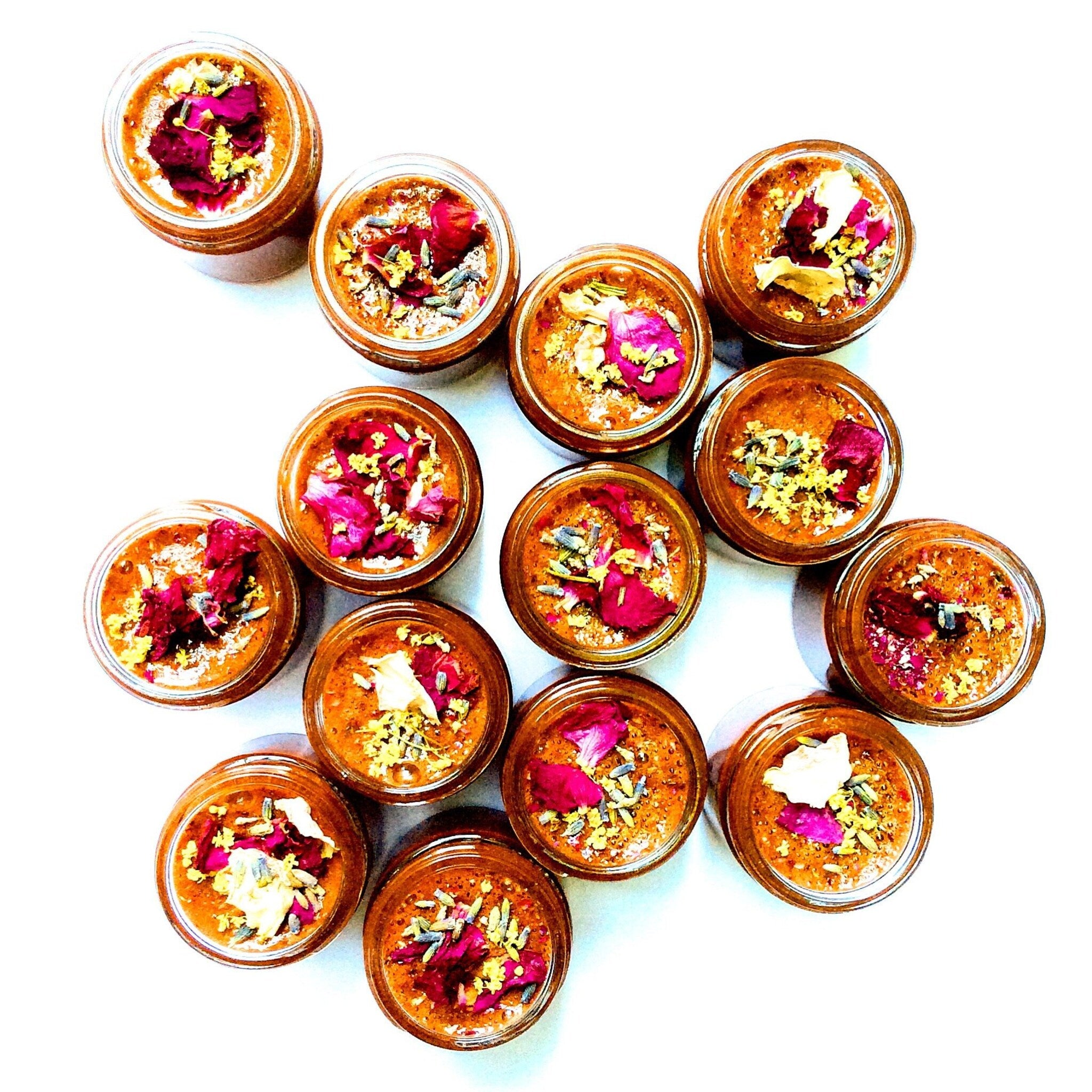 Jarred product with brown contents, red petals, and yellow accents on white background