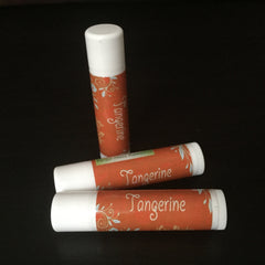 Lip balm tubes with orange and white labels, floral pattern, and "Tangerine" text