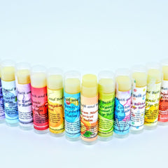 Lip balm tubes with various colored labels and clear caps, Ancient Bath and Body brand visible