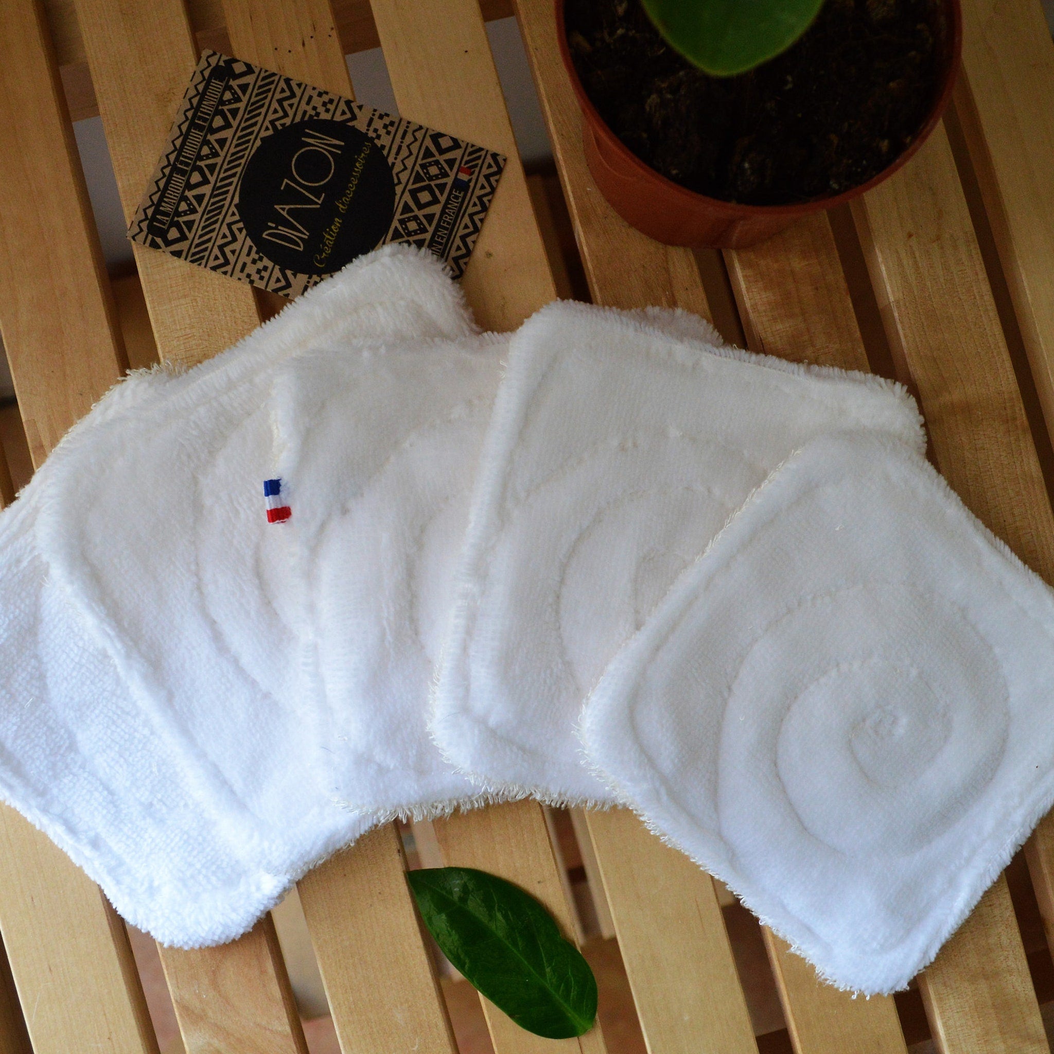 Stacked bamboo makeup remover wipes in reusable pouch with OEKO-TEX certification label visible