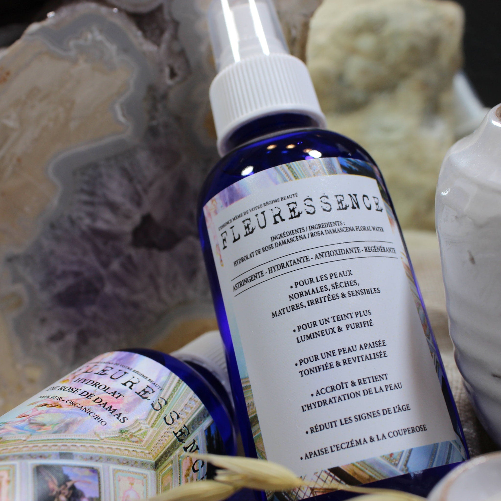 Rose water spray bottle with blue glass, white sprayer, and FLEURESSENCE label visible