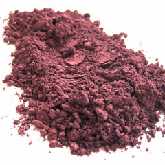 Close-up of mulberry-hued mineral eye shadow with shimmering pigment in compact case