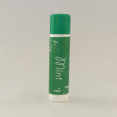Lip balm tube, green with white "Mint" text and floral design, white base