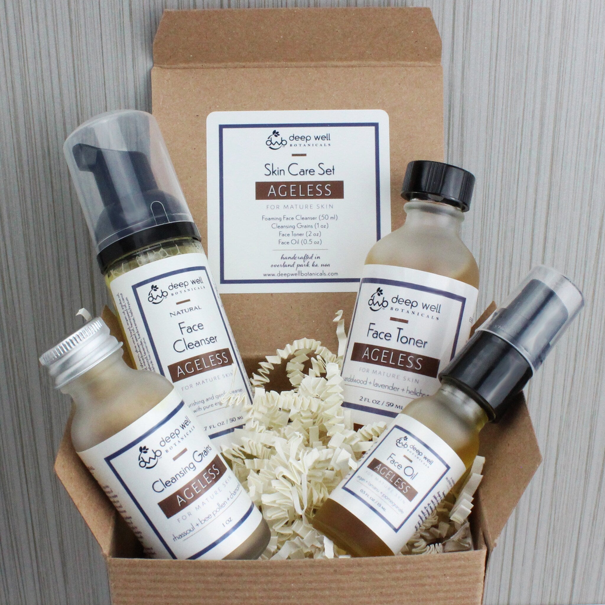 Skin care set with brown bottles, white labels, and Deep Well Botanicals branding in a cardboard box