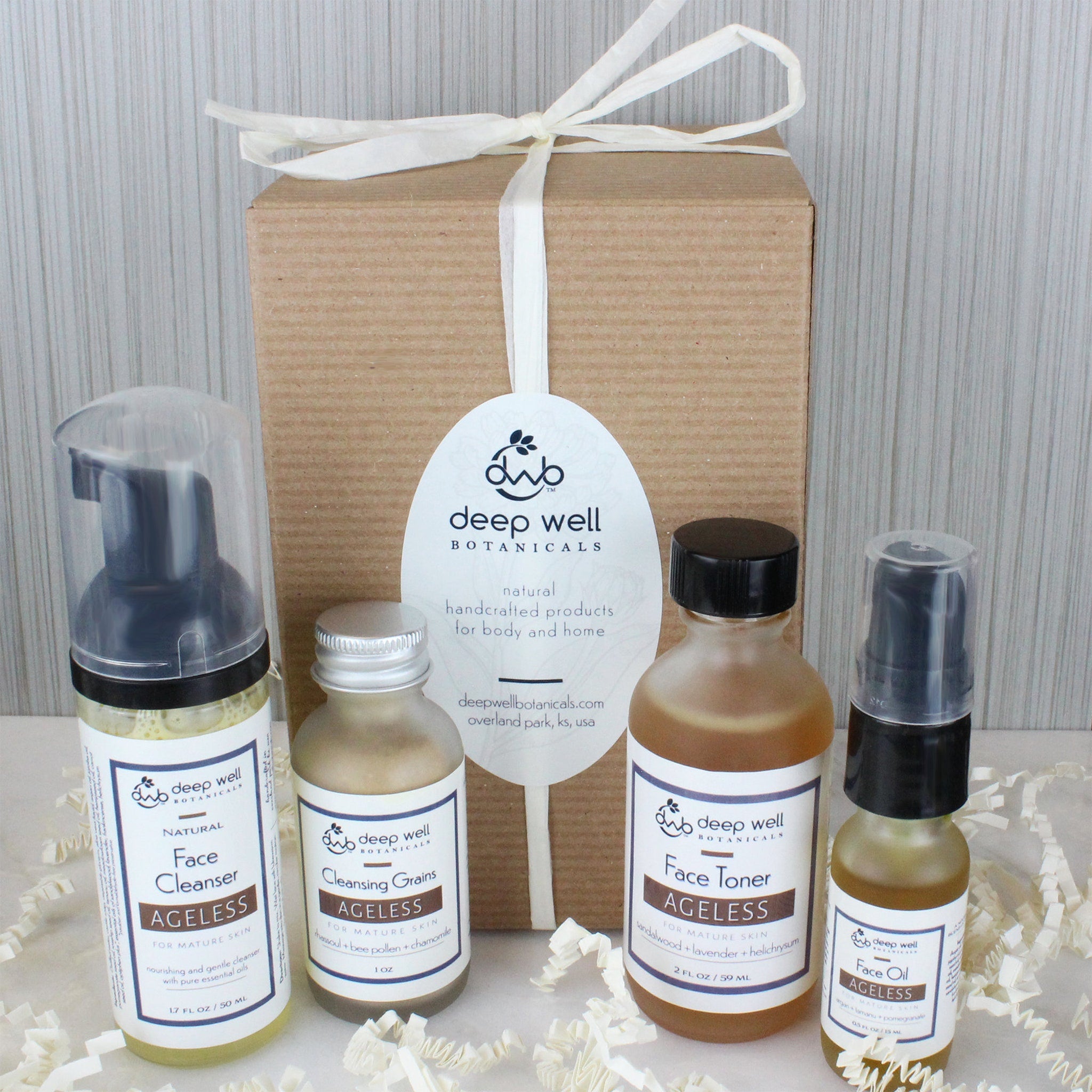 Skincare gift set with brown box, white ribbon, and Deep Well Botanicals labels.