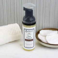 Face cleanser bottle with black pump, clear cap, and white label, with Deep Well Botanicals text