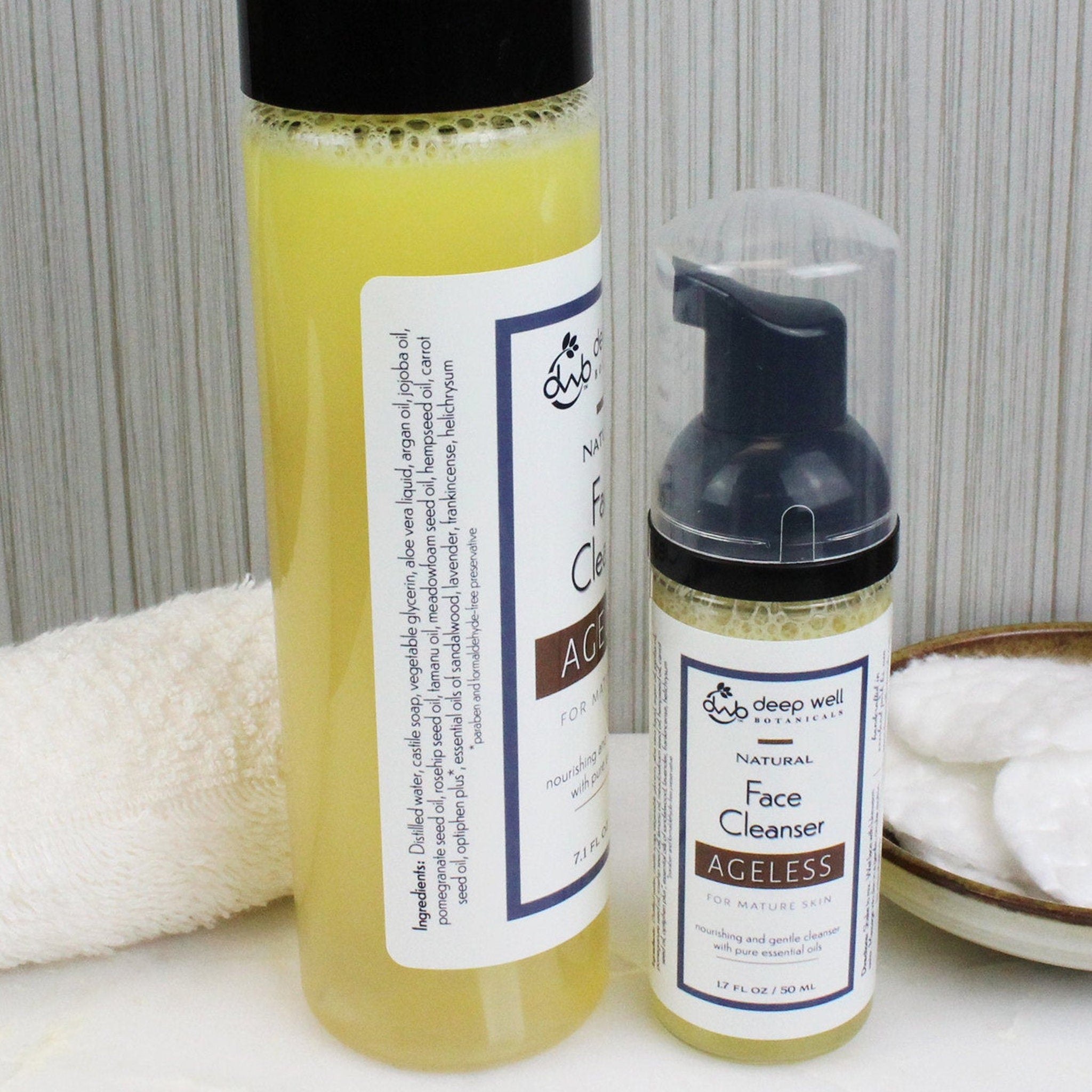 Face cleanser bottles with yellow liquid, black caps, and white labels with "deep well botanicals" text