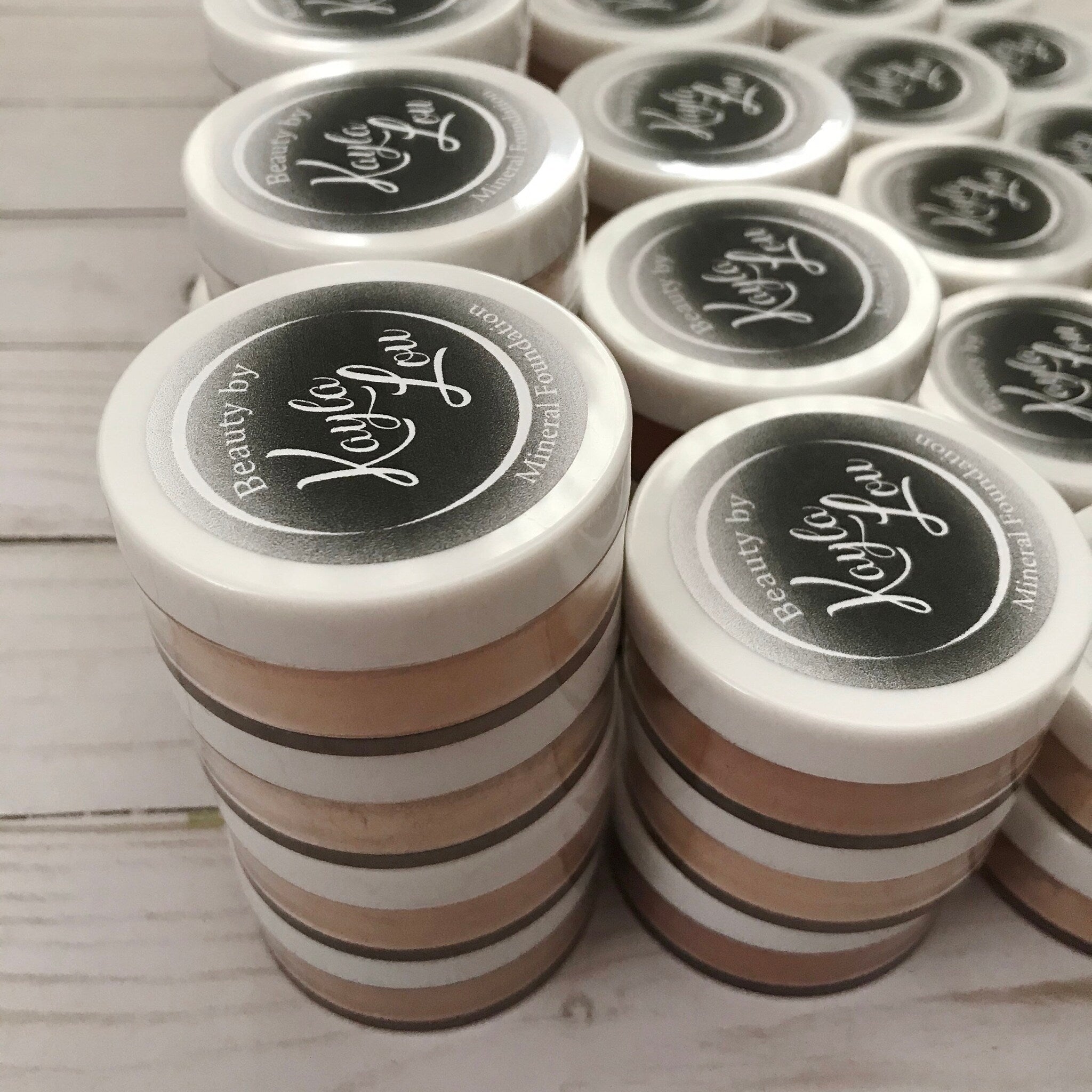 Mineral foundation in white and tan striped jars with Kayla Lou branding on top