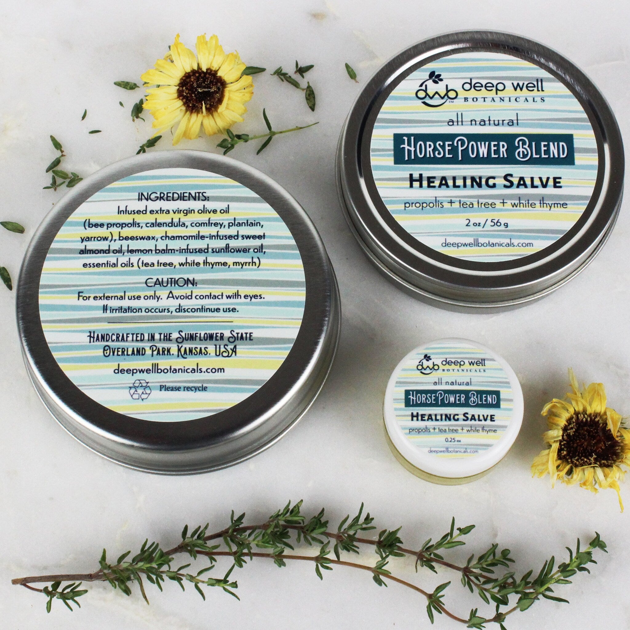 Healing salve tins, metal containers with blue and yellow striped labels, Deep Well Botanicals brand