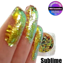 Extreme close-up of multichrome eyeshadow flakes showing shifting iridescent hues from purple to green