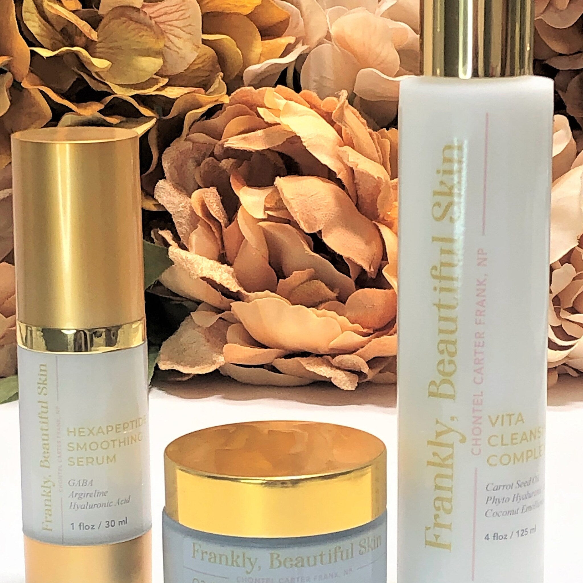 Skincare products with gold lids and Frankly, Beautiful Skin branding on white bottles and jars