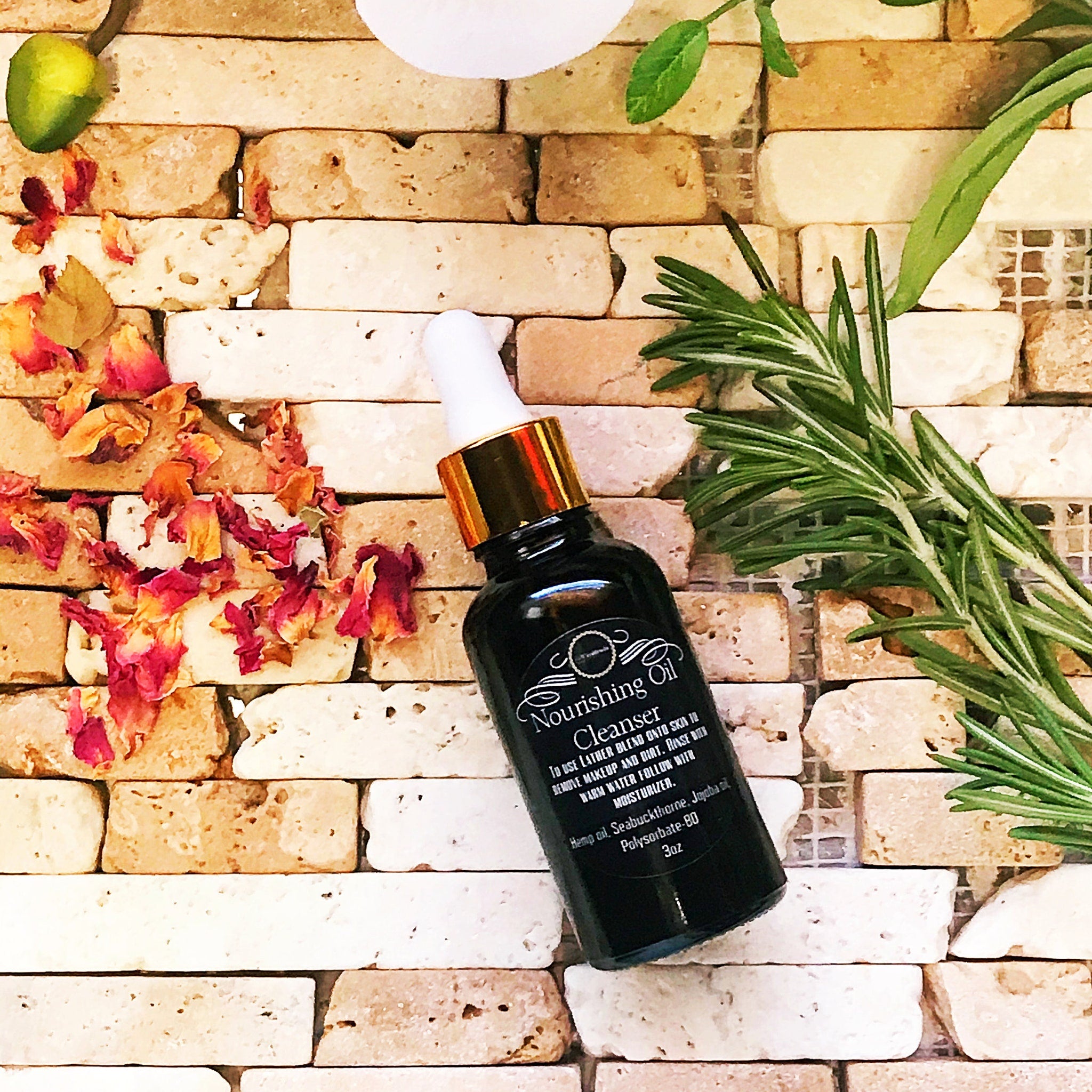 Cleanser bottle with gold cap, black glass, and "Nourishing Oil" label on brick background