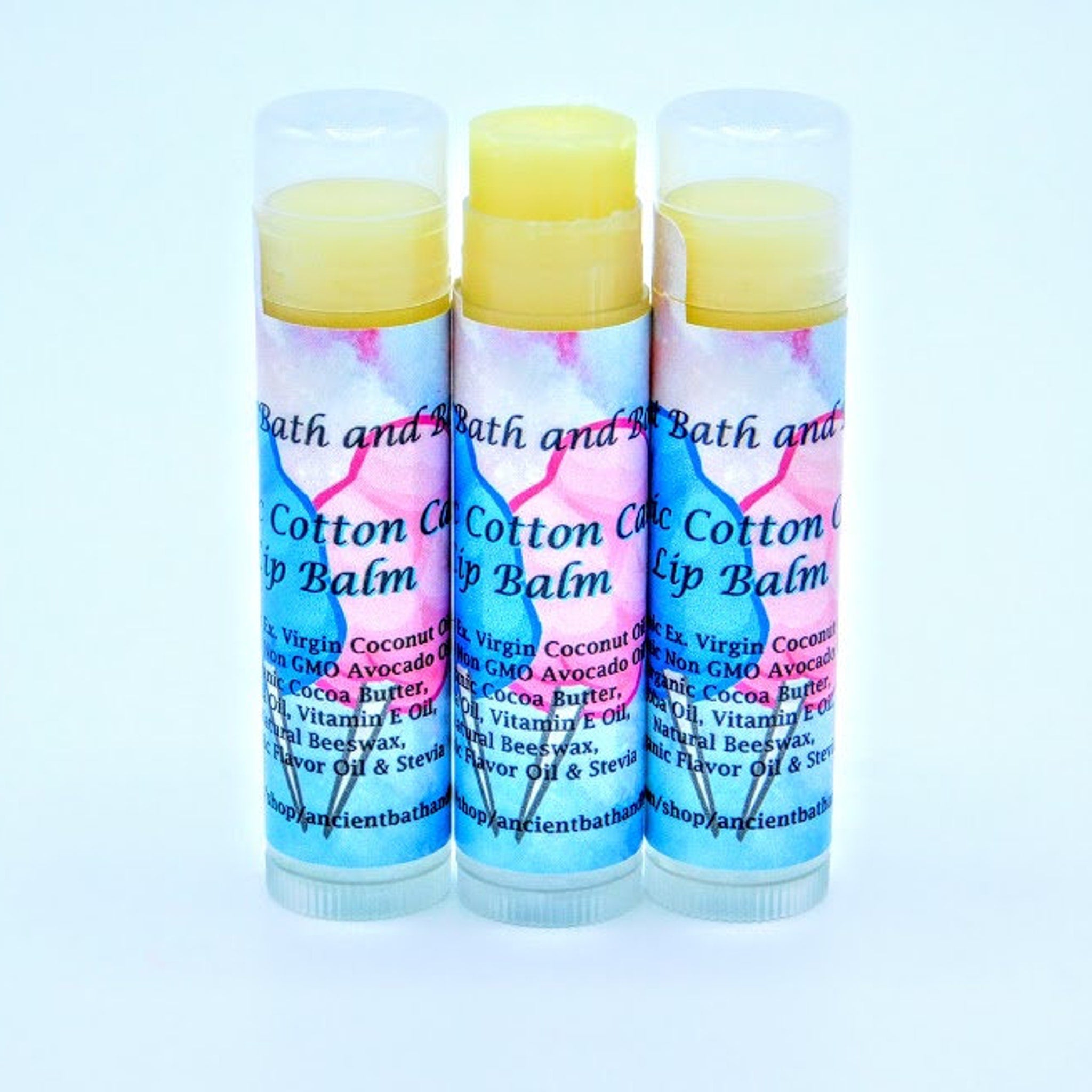 Lip balm tubes with yellow balm, patterned blue and pink label, and brand text