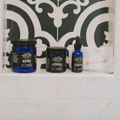 Skincare products in blue and black jars with "unbelievable skincare" label on white shelf