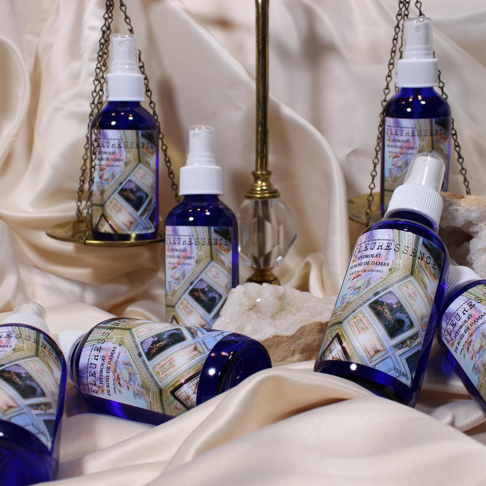 Rose water spray bottles, blue glass, white spray top, "FLEURESSENCE" label visible