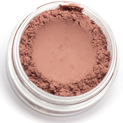 Close-up of matte beige pink mineral eyeshadow with soft powdery texture in compact pan