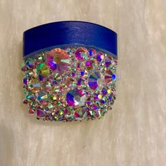 Blue and iridescent rhinestone container with jeweled embellishments on white background