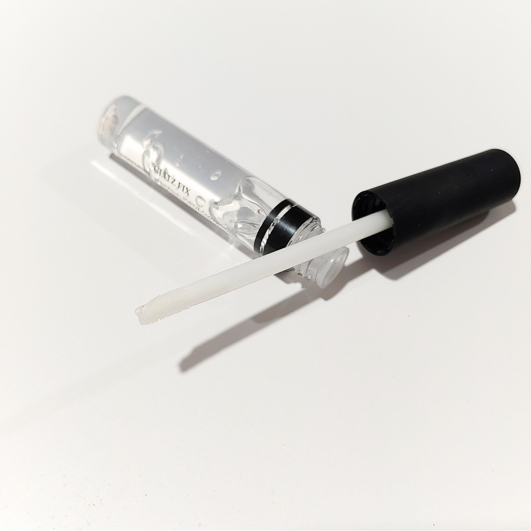 Close-up of glitter glue being applied to eyelid with fingertip, showcasing shimmering highlighter effect