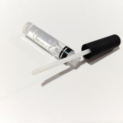 Close-up of glitter glue being applied to eyelid with fingertip, showcasing shimmering highlighter effect