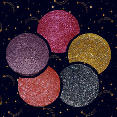 Four shimmering eyeshadow pans in bronze, gold, rose, and plum shades with mirrored compact packaging