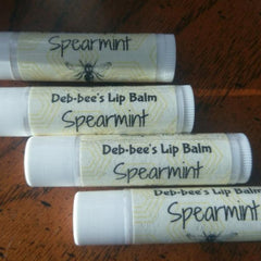 Spearmint lip balm tubes with white plastic, yellow label, and black text of Deb-bee's Lip Balm and Spearmint