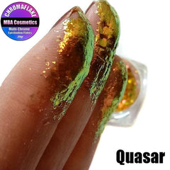 Extreme close-up of Quasar Chromaflake eyeshadow flakes showing vibrant multichrome color shift and glitter particles