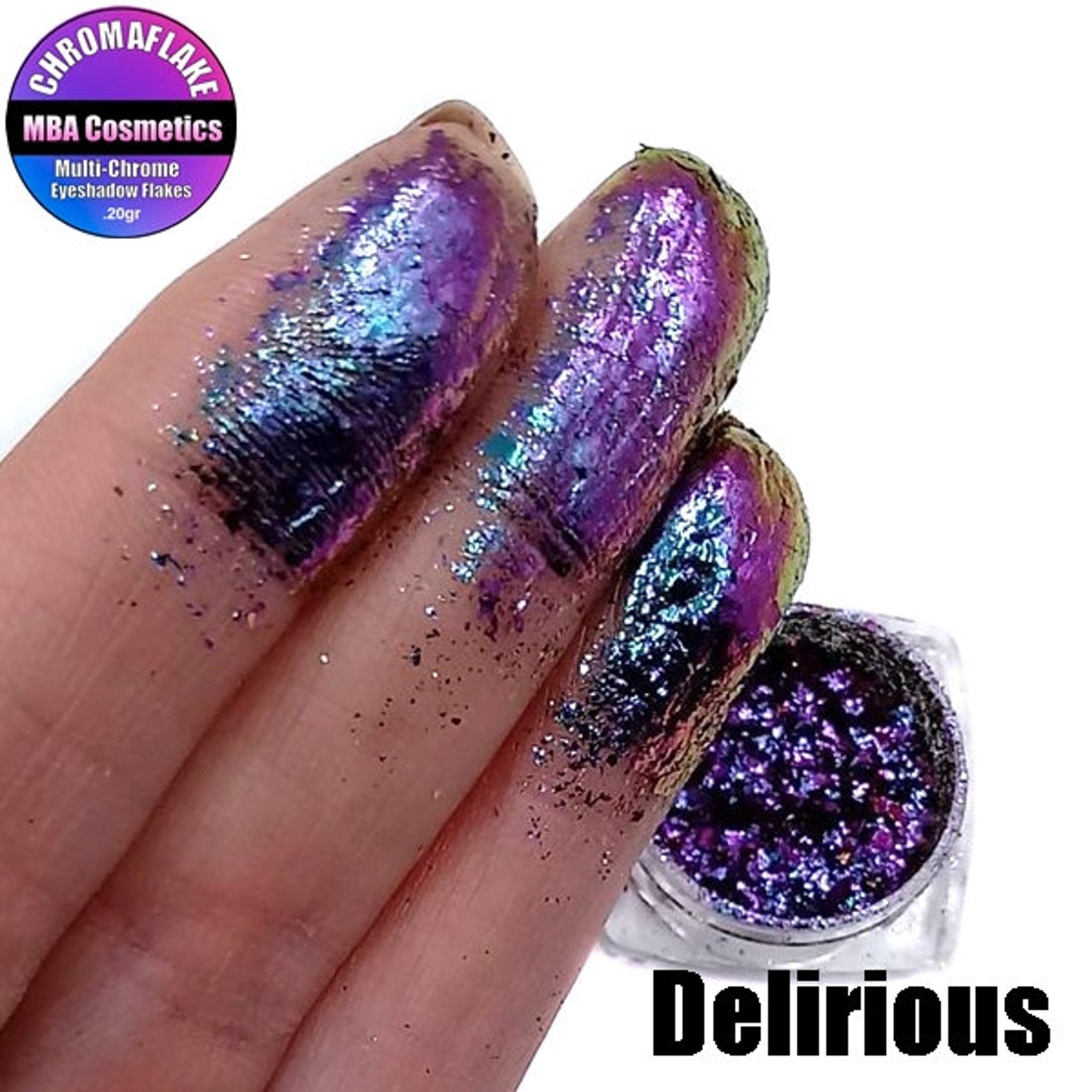 Close-up of Delirious Chromaflake eye shadow flakes showcasing multichrome metallic shift from purple to green