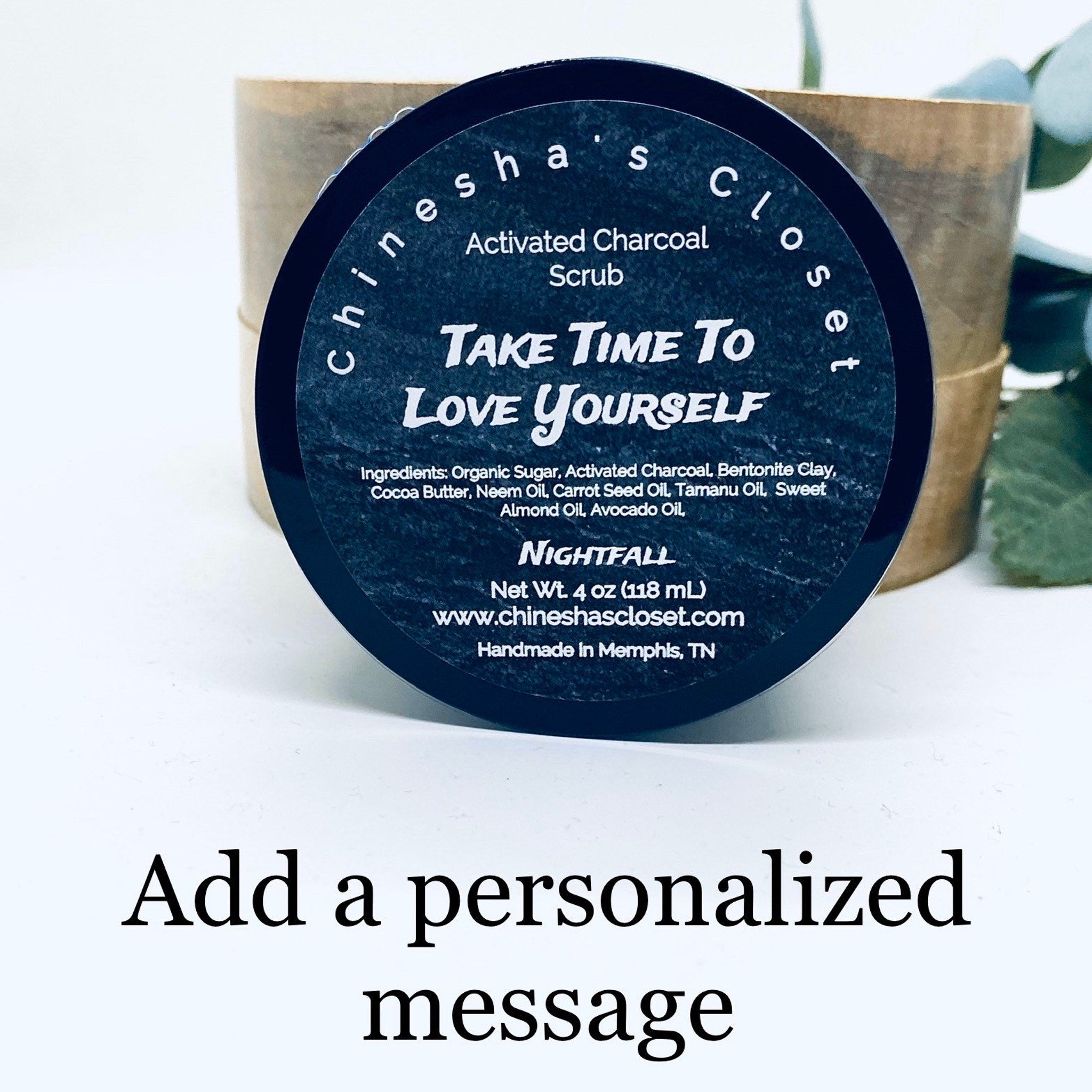 Activated charcoal scrub with black label, white text, and "Chinesha's Closet" branding, displayed in a wooden container
