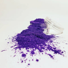 Hand applying shimmering taupe mineral eyeshadow with a fluffy brush for a reflective finish