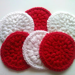 Crocheted coasters in red and white yarn with textured pattern and round shape