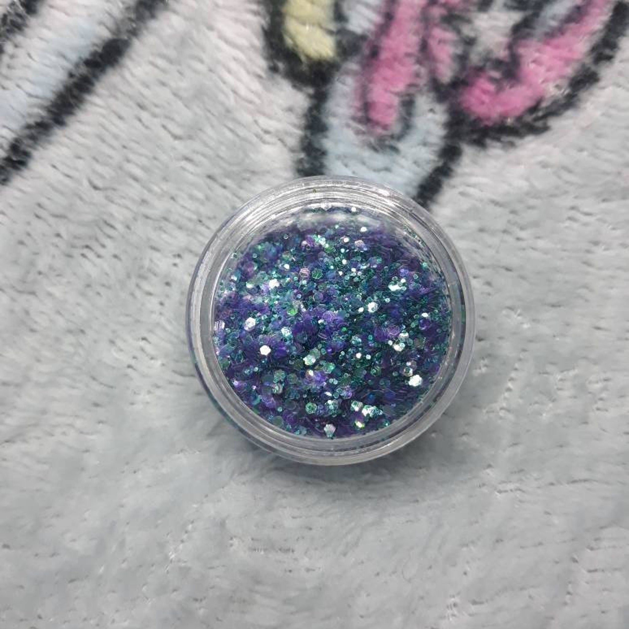 Close-up of iridescent mermaid scales eye shadow with shimmering teal and purple hues