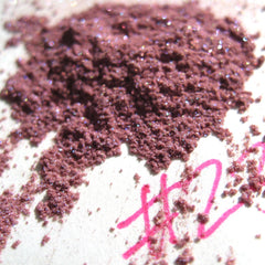 Dusty rose powder with glitter, scattered on white surface with pink markings