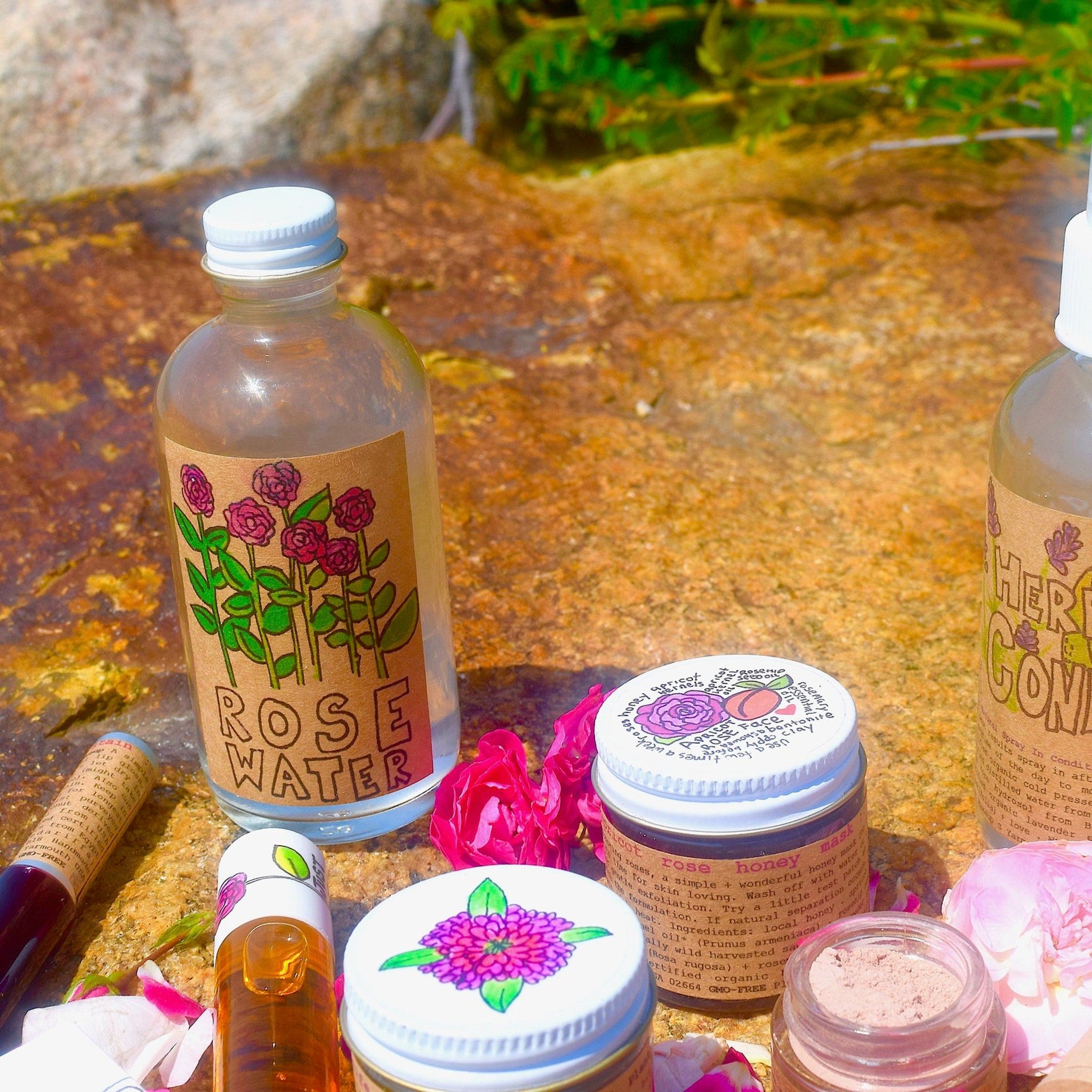 Rose water bottle with rose label, clear glass, white cap, and floral illustration