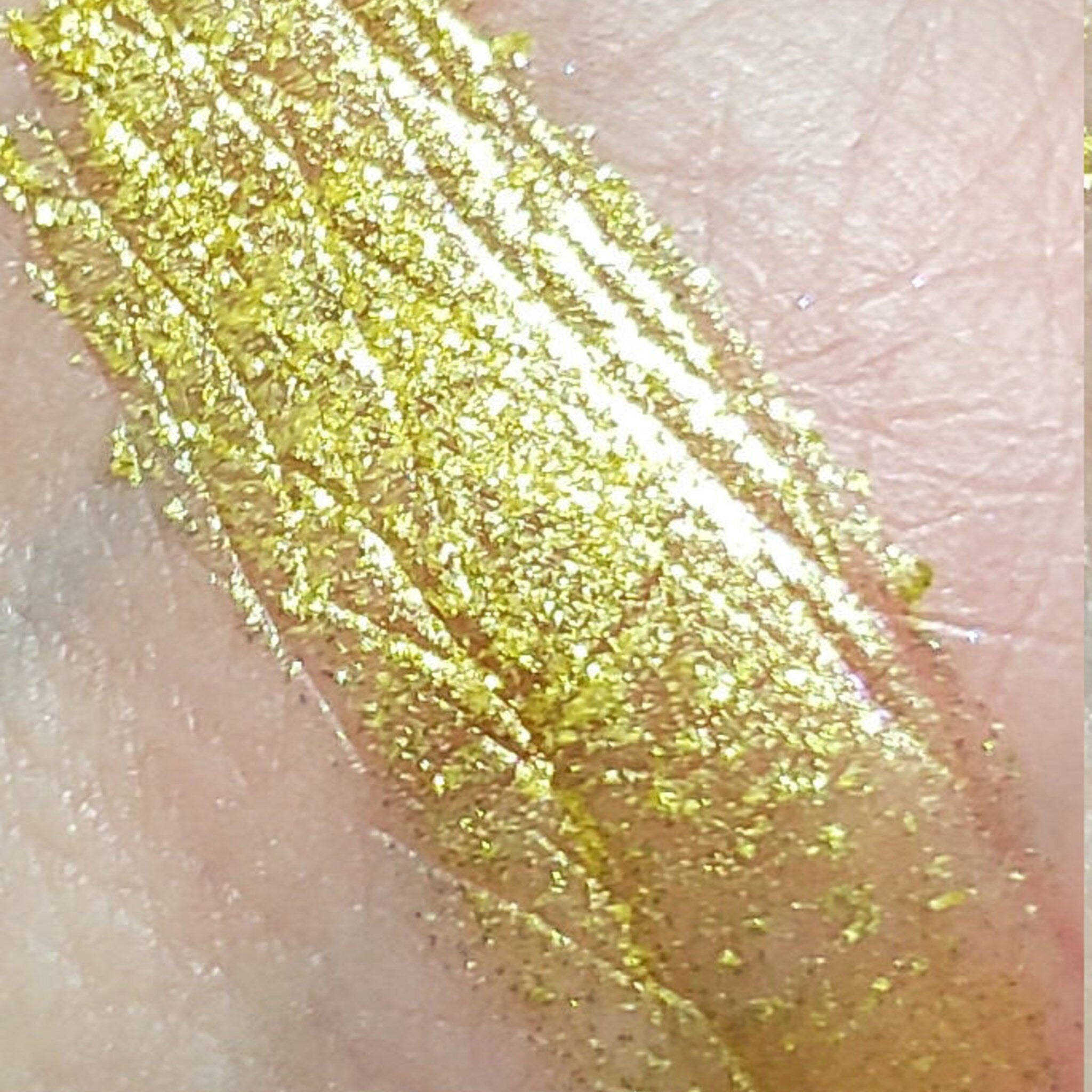 Front view of Sparklers eyeshadow palette showing four vibrant powder shades in square pans with gold packaging