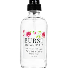Facial mist bottle with black pump, clear glass, and white label with floral design and text BURST BOTANICALS